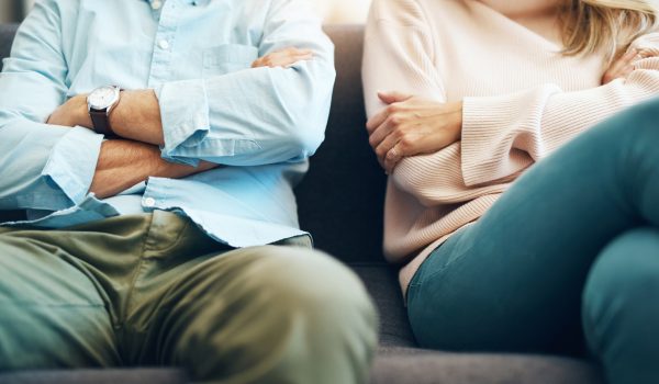 Cropped shot of an unrecognizable mature couple sitting on the sofa with their arms folded after an argument